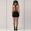Rear view of model showcasing wide open back design with central vertical strap displaying white THIGHBRUSH logo down the
