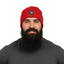 Man wearing a red THIGHBRUSH beanie with a logo and a gray t-shirt on a white background